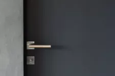 A door handle and knob on a wall, providing access to a room