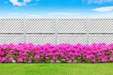 A fence adorned with vibrant pink flowers in the foreground
