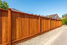 A gravel driveway leading to a wooden fence