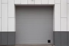 A large gray garage door against a white wall