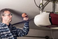 A man repairing a garage door opener