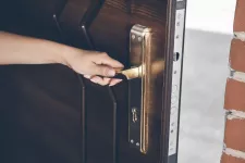 A person's hand on a handle that opens the door