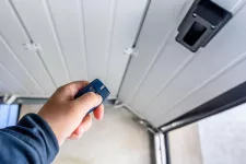 A person using a remote control to open a garage door