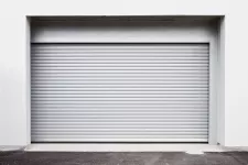 A rolling garage door against a white wall, blending seamlessly, creating a clean and minimalist aesthetic