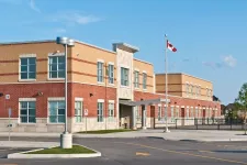 A school building with a flag pole and a parking lot