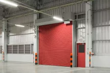 A spacious industrial warehouse with vibrant red roller door