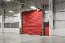 A spacious warehouse with vibrant red roller doors.