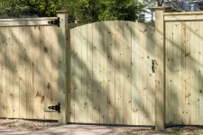 A wooden fence with a gate and gate: a rustic barrier made of wood, featuring a gate for entry and exit.