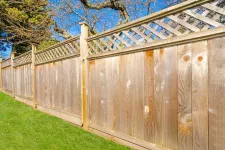 A wooden fence with a lattice pattern on top, providing privacy and adding an elegant touch to the surroundings