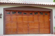 A wooden garage door with a brown tiled roof
