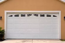 A white garage door in front of a garage.