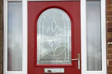 A red front door with a glass window, inviting and elegant.