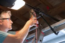 A man repairs a garage door opener.