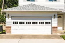 White garage door with 8-pane windows on a vinyl and brick house