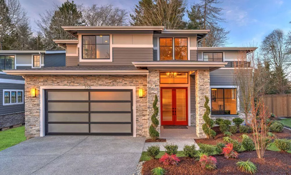 A contemporary house with a garage and well-maintained landscaping, showcasing modern architectural design