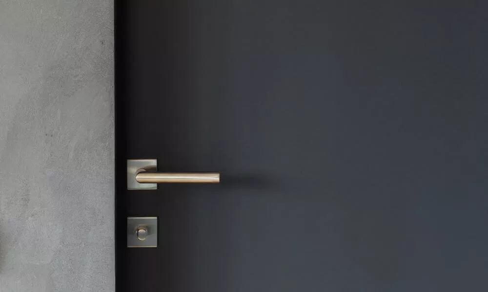 A door handle and knob on a wall, providing access to a room