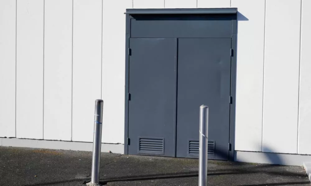 A door with metal poles on the side of a building