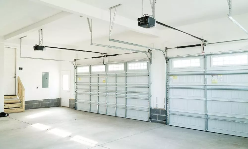 A garage with two garage doors and a staircase