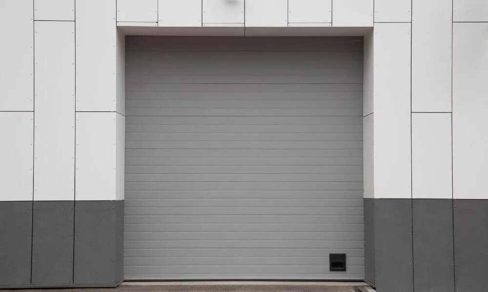 A large gray garage door against a white wall