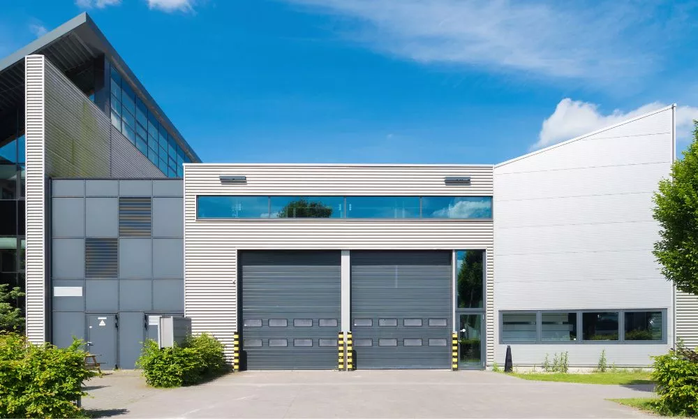 A large industrial building with two large doors, suitable for manufacturing or storage purposes.
