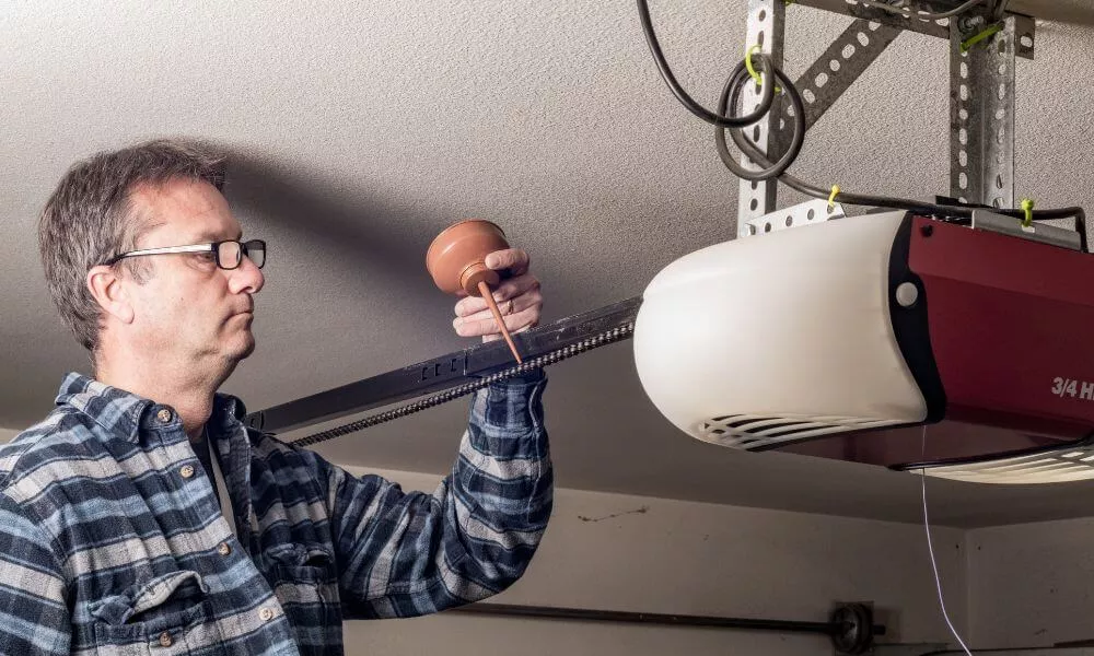 A man repairing a garage door opener