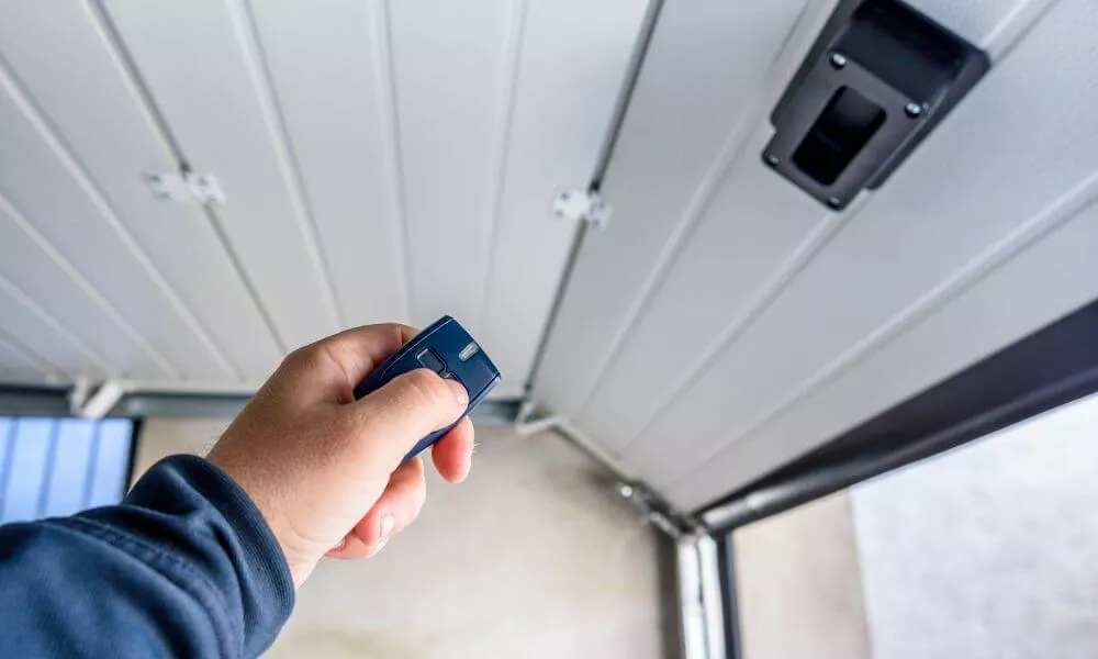 A person using a remote control to open a garage door