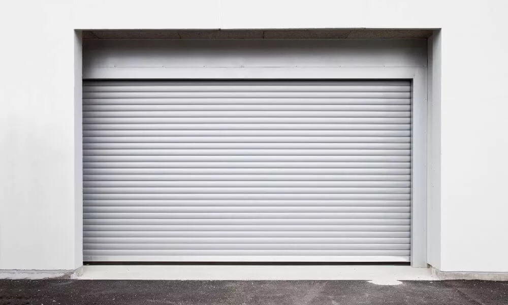 A rolling garage door against a white wall, blending seamlessly, creating a clean and minimalist aesthetic