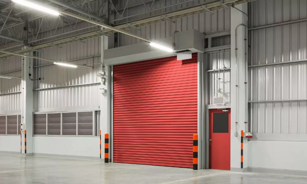 A spacious industrial warehouse with vibrant red roller door