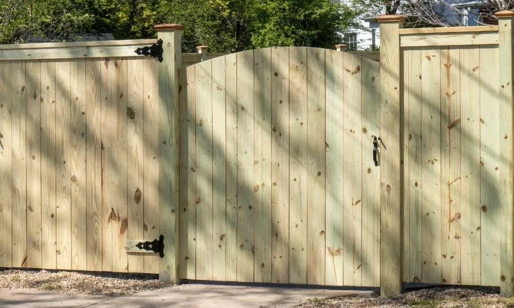 A wooden fence with a gate and gate: a rustic barrier made of wood, featuring a gate for entry and exit.