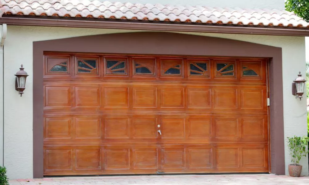 A wooden garage door with a brown tiled roof