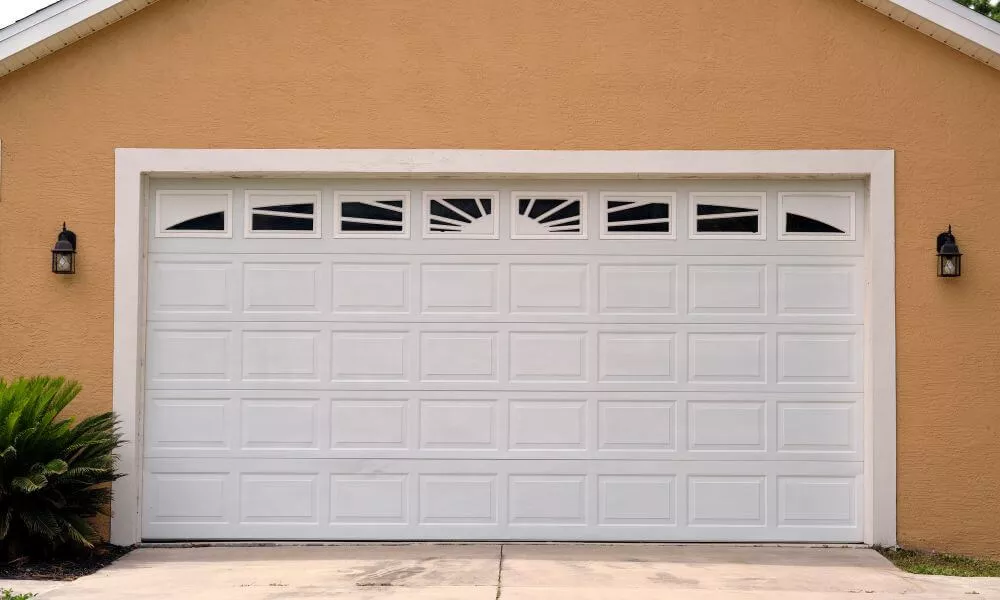 A white garage door in front of a garage.