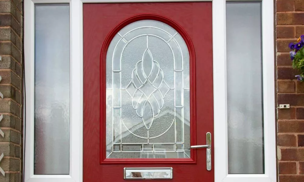 A red front door with a glass window, inviting and elegant.