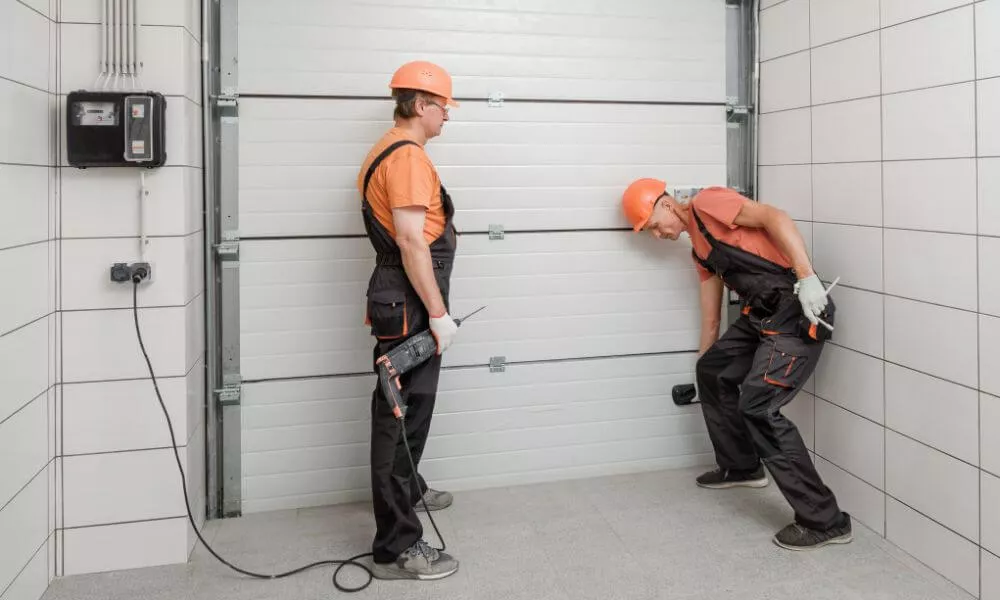 Two men repairing a garage door