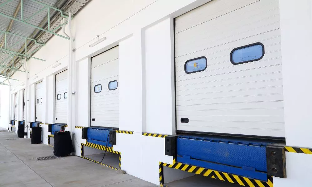 A row of white industrial doors with blue and yellow stripes, providing a vibrant and eye-catching appearance.
